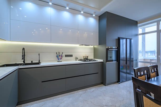 Spacious luxury white and dark grey modern kitchen interior with dining table