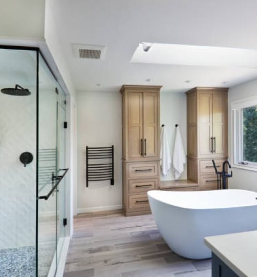 A contemporary modern bathroom design. featuring a freestanding bathtub and a glass shower stall