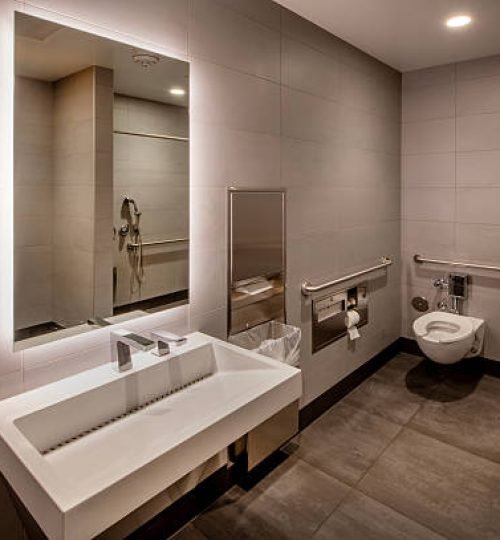 Upscale restroom with shower stall reflected in mirror.